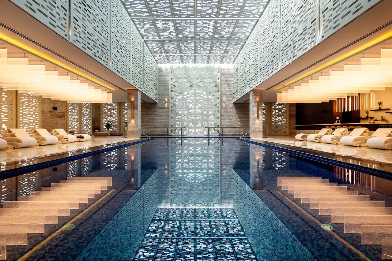 indoor pool with white pool chairs on both sides