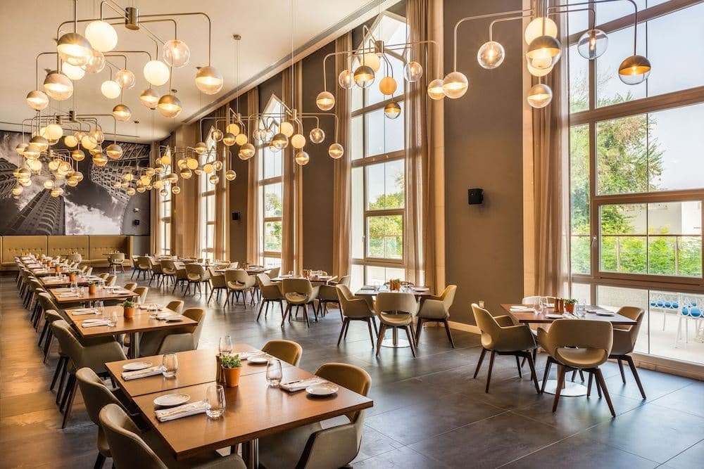hotel restaurant tables chairs with windows chandeliers