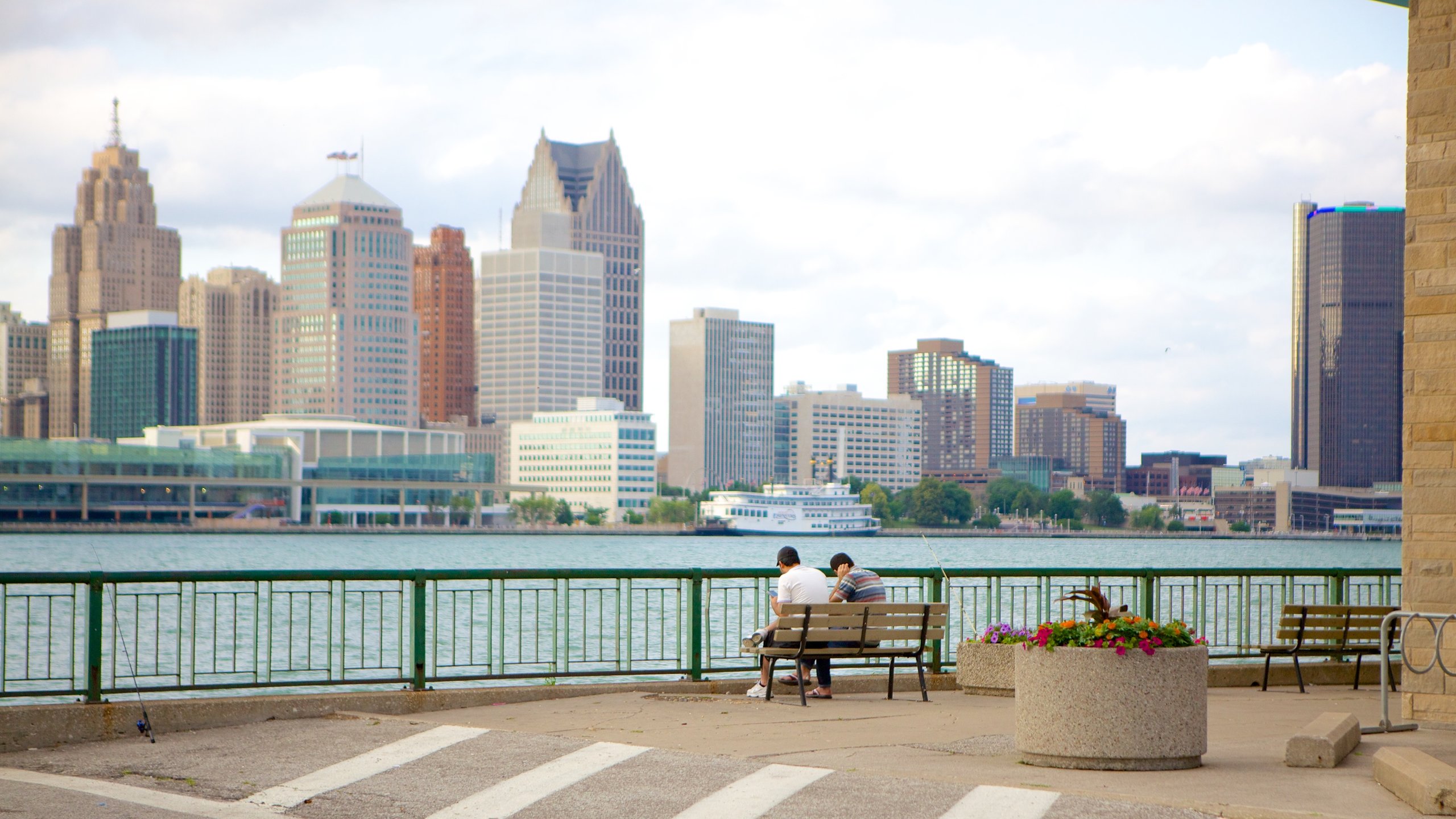 two people sitting on bench facing buildings