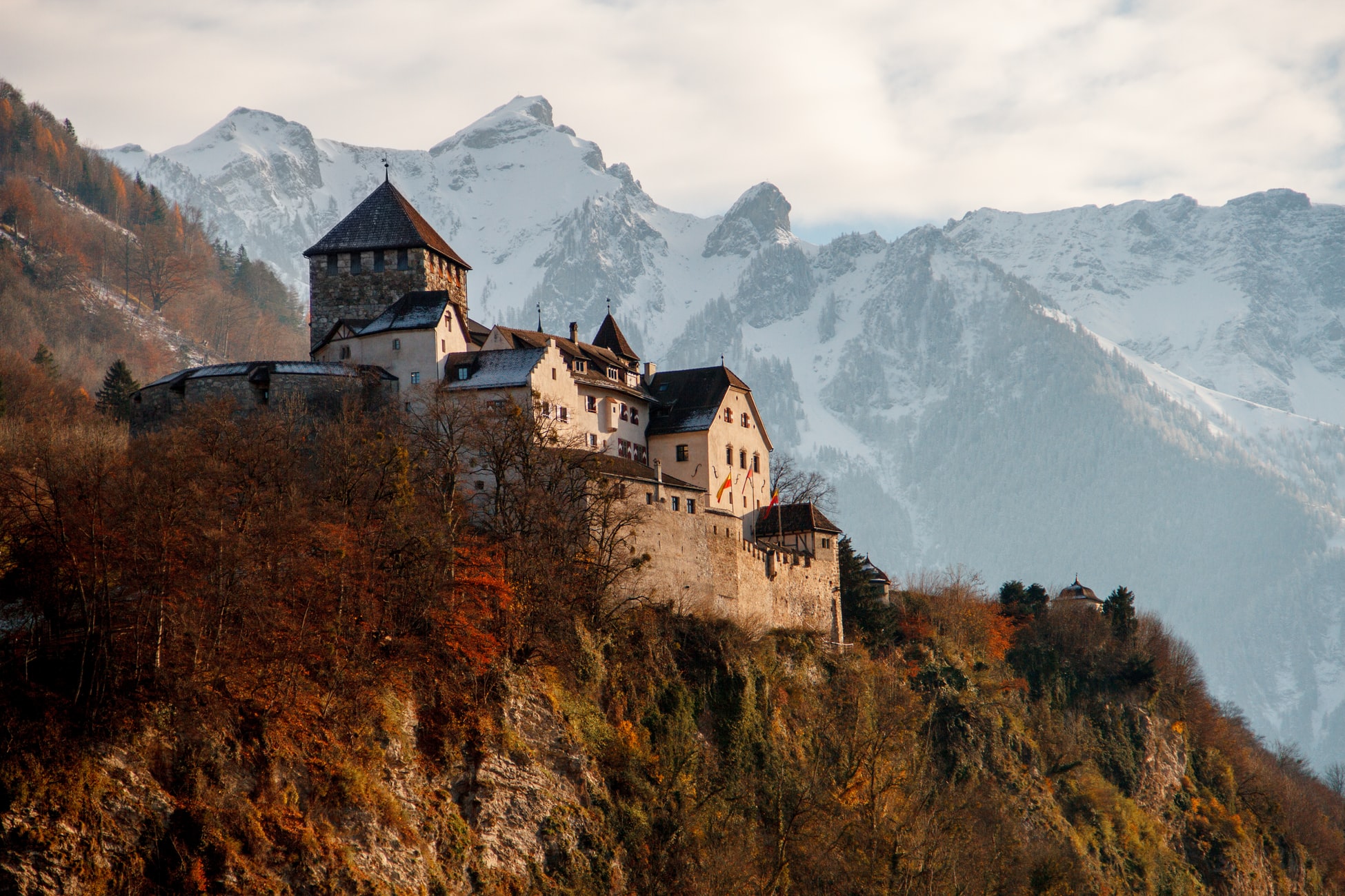 castle on hilltop surrounded by mountains