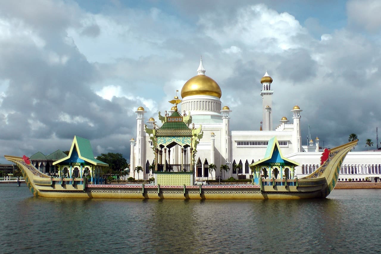 boat along river in front of mosque