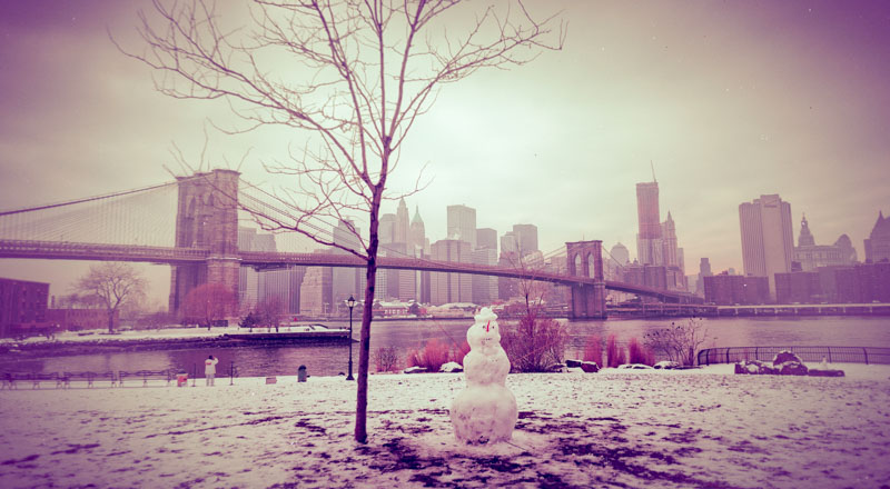 Snowman against NYC skyline in winter