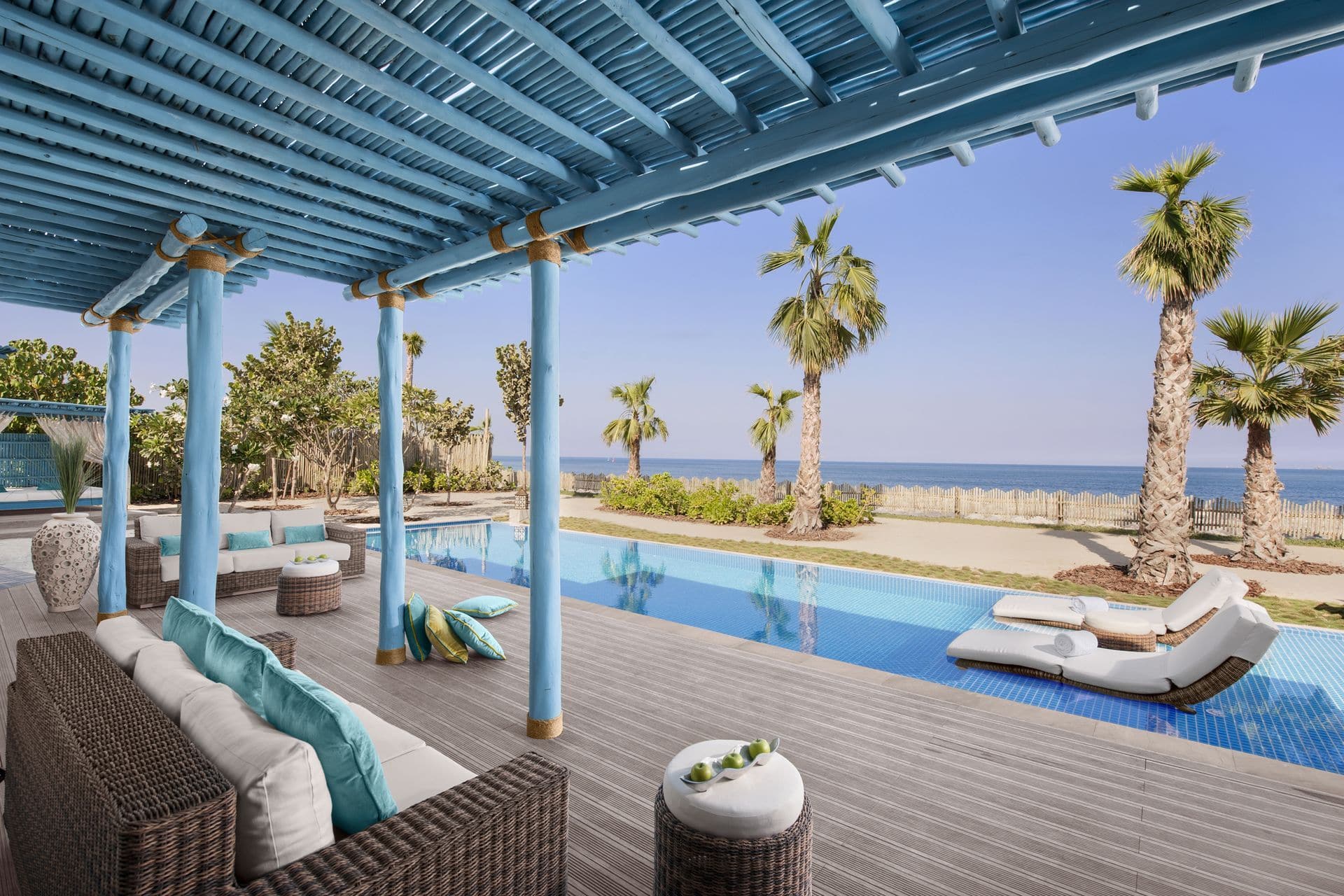 outdoor pool with blue roof palm trees
