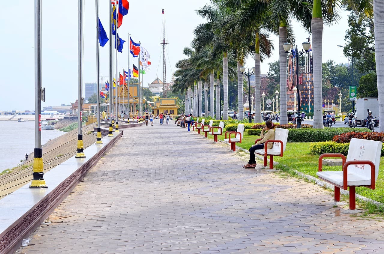 people sitting on riverfront benches