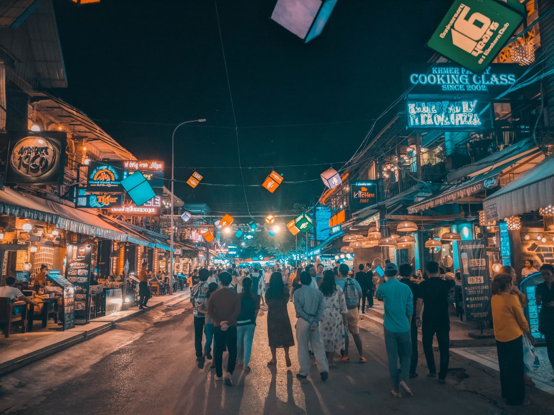 people walking along street lined with restaurants