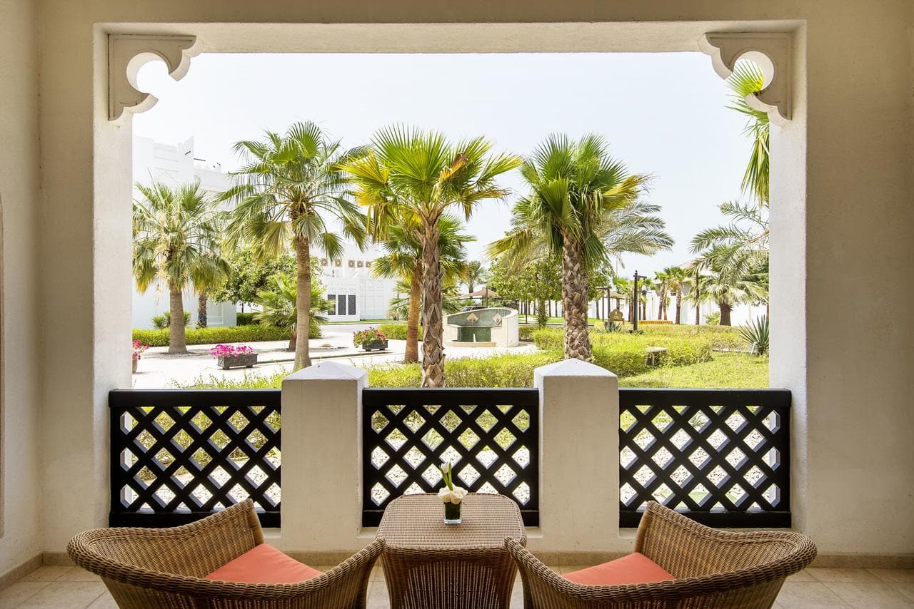 view from balcony overlooking garden with palm trees
