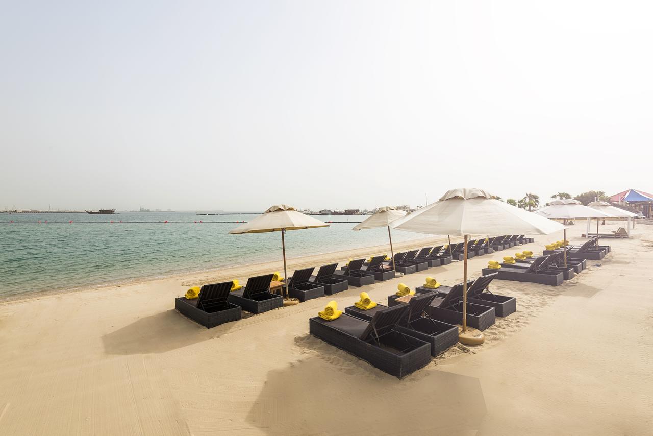 lounge chairs by the beach with white umbrellas