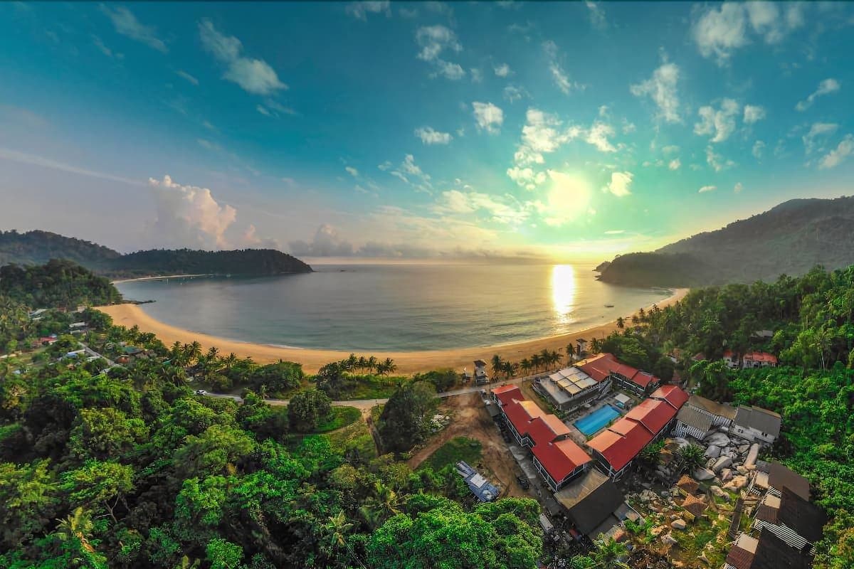 aerial shot of island with trees at sunset